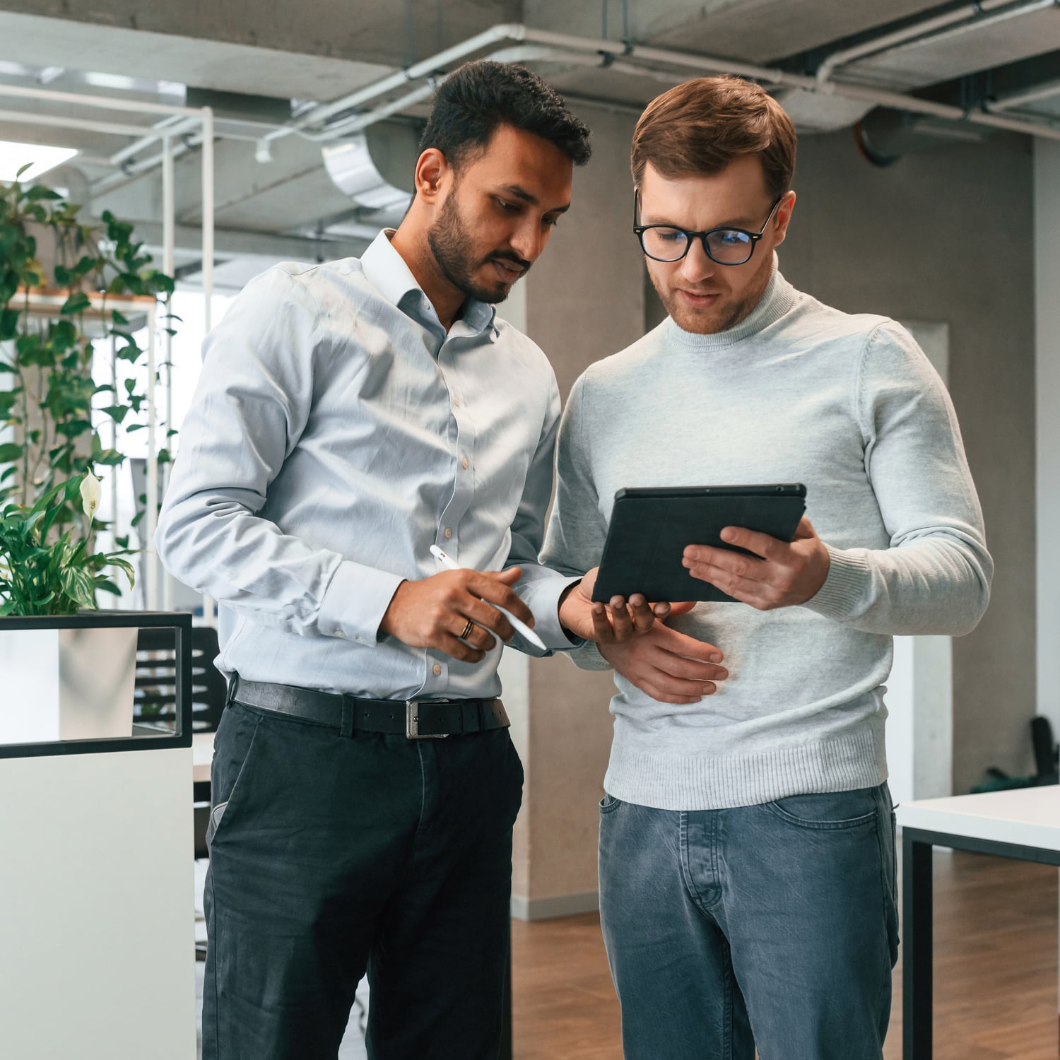 Photo of two men looking at a digital tablet together