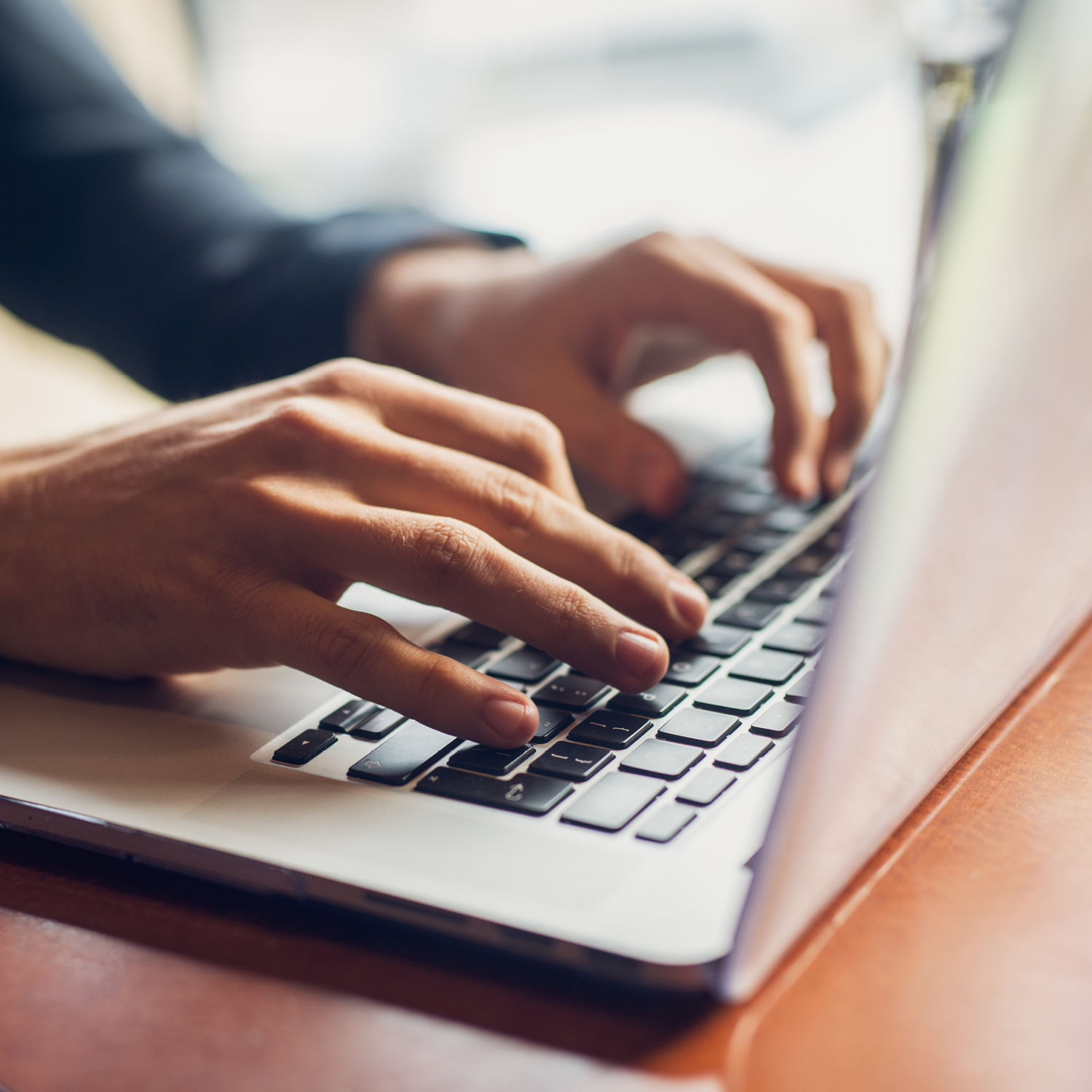 Photo of hands typing on a laptop